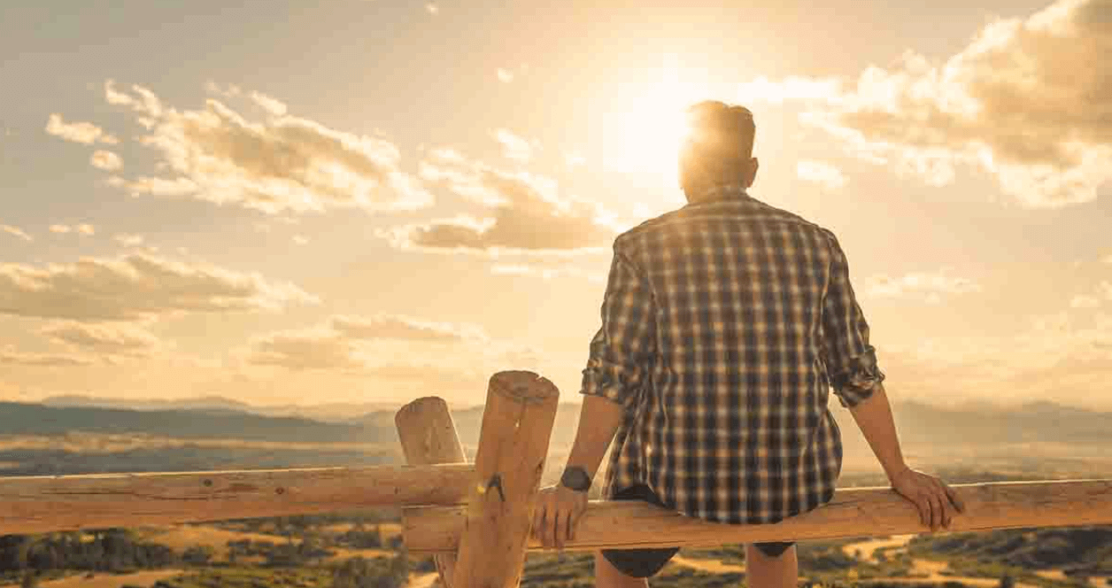 Man sitting watching the sunset, experiencing drug rehab