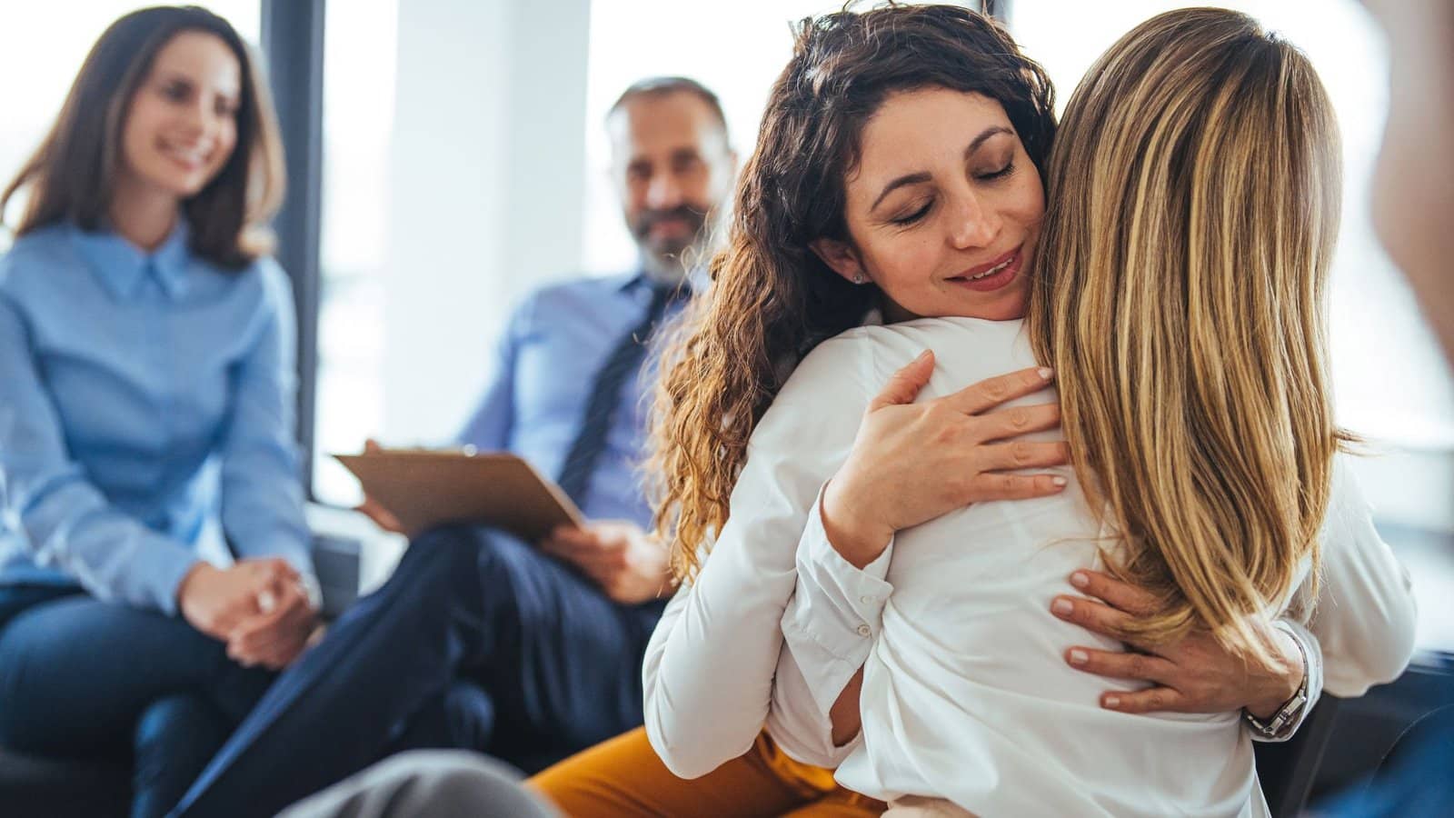 Woman overcomes addiction through therapy. Her therapist gives her a hug.