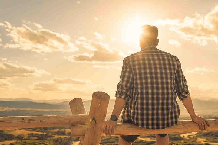 Man sitting watching the sunset, experiencing drug rehab